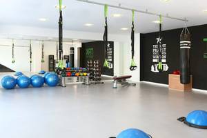 Fitnessstudio im Iberostar Playa de Muro Hotel mit TRX-Trainingsgeräten und Hanteln.