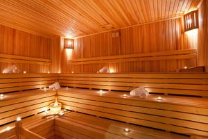 Innenansicht der Sauna im Sherwood Dreams Resort mit Holzbänken und Kerzenlicht