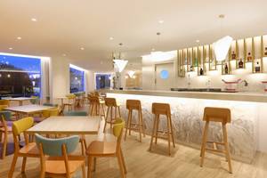 Innenbereich des Iberostar Playa de Muro Hotels mit Bar und Sitzgelegenheiten.
