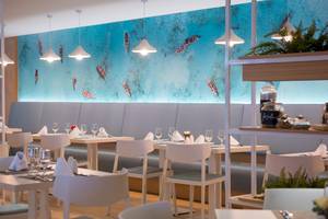 Speisesaal des Iberostar Playa de Muro Hotels mit modernem Interieur und Meerestapete.