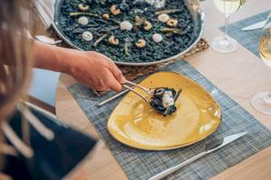 Essen genießen im Iberostar Playa de Muro Hotel mit einer Person, die eine Mahlzeit mit einer Serviette serviert.