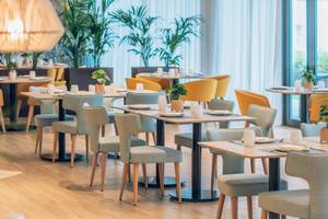 Restaurant des Iberostar Playa de Muro Hotels mit gedeckten Tischen und Stühlen.