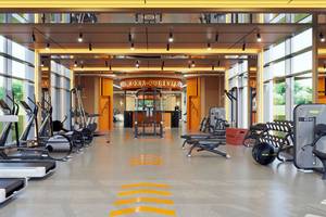 Fitnessstudio im Gloria Serenity Resort mit Laufbändern, Hanteln und anderen Geräten.
