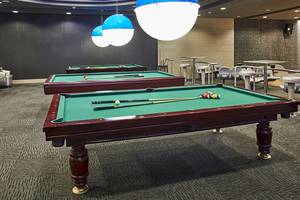 Zwei Billardtische im Gloria Golf Resort mit Ballkugeln und Stöcken.