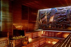 Innenansicht der Sauna im Gloria Golf Resort mit Holzwänden und einem großen Wandbild.
