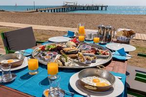 Frühstück am Strand im Xanadu Resort Hotel mit Blick auf das Meer und eine lange Pier.