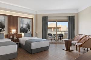 Doppelzimmer im Xanadu Makadi Bay Hotel mit zwei Betten, modernem Interieur und Balkonzugang.