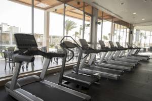 Fitnessstudio im Xanadu Makadi Bay Hotel mit einer Reihe von Laufbändern und großen Fenstern.