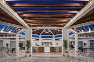 Innenansicht der Lobby des Xanadu Makadi Bay Hotels mit Holzdecken und Tischen.