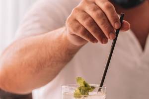 Hand des Bartenders des Aimia Hotels, der einen Cocktail mit Minze zubereitet