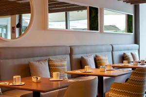Innenbereich des Aimia Hotels, Tisch und Stühle in einem Restaurant mit modernen Möbeln und Dekoration.