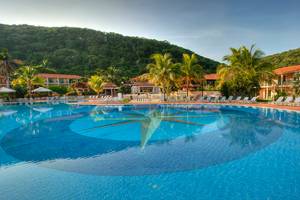 Außenpool des Memories Jibacoa Resorts mit Liegestühlen und Palmen im Hintergrund
