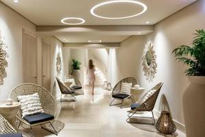 Innenbereich des Spas im Ikos Dassia Hotel mit runden Leuchten, Rattanmöbeln und Pflanzen.