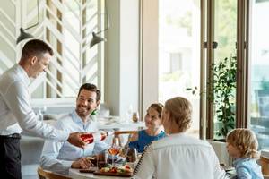 Eine Familie im Restaurant bei einem Essen im Ikos Dassia.