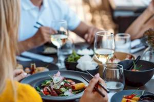 Leute essen im Restaurant mit verschiedenen Gerichten und Getränken