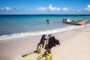 Strand mit Tauchausrüstung und einem Boot im Wasser am Memories Jibacoa Resort