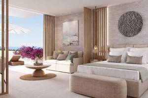Hotelzimmer Interieur mit Bett, Couch und Blick auf das Meer im Ikos Odisia.