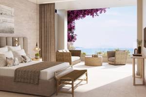 Ein modernes Hotelzimmer im Ikos Odisia mit Ausblick auf das Meer.
