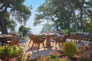 Gartensitzplatze mit Tischen und Stühlen im Freien im Ikos Odisia Hotel