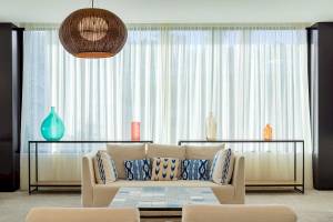 Wohnzimmer im H10 Casa del Mar Hotel mit Couch, Tisch und Dekorationsgegenständen.