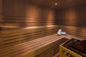Sauna im H10 Casa del Mar Hotel mit Holzbänken und Handtüchern.