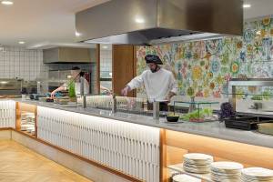Restaurantbuffetservice im H10 Casa del Mar Hotel mit Küchenpersonal und gedeckten Tischen.