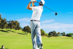 Golfspieler beim Schwung auf einem Golfplatz im Freien.