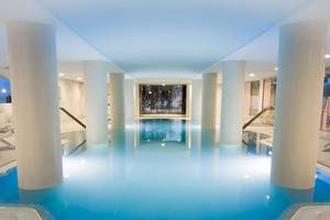 Innenpool des CM Castell de Mar Hotels mit blauem Wasser und weißen Säulen