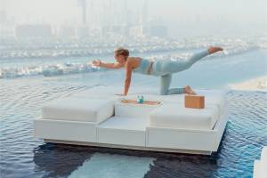 Eine Frau praktiziert Yoga auf einer schwimmenden Couch im Atlantis The Royal.