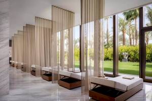 Innenansicht des Wellnessbereichs im Atlantis The Royal Hotel mit langen weißen Vorhängen und Betten.