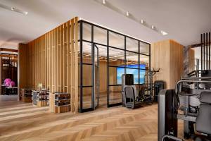 Fitnesscenter-Innenansicht von Atlantis The Royal mit Holzwänden und Glastüren.
