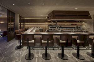 Innenansicht des Restaurants im Mandarin Oriental, Costa Navarino, mit langen Tischen und Stühlen.