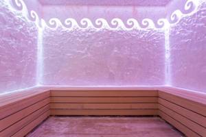 Rosa beleuchtete Sauna im Eftalia Ocean Hotel mit hölzernen Sitzbänken