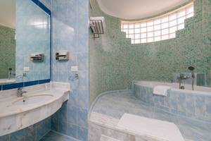 Badezimmer im Siva Golden Bay Makadi Hotel mit blauen Fliesen und Badewanne.