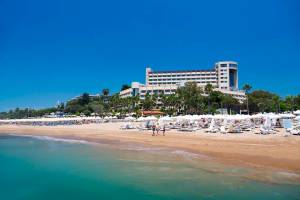 Strand des Melas Resorts mit vielen Liegestühlen und Sonnenschirmen.