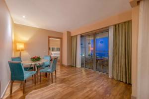 Essbereich im Melas Resort mit runden Tisch und blauen Sesseln vor einem großen Fenster
