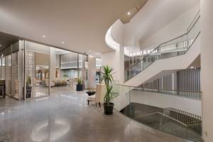 Innenbereich der Lobby des Melas Resorts mit Aufzug, Pflanzen und modernen Möbeln.