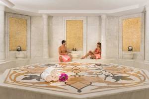 Innenansicht des Dampfbades im Melas Resort mit zwei Gästen und dekorativen Elementen.
