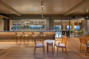 Innenansicht der Bar im Melas Resort mit hölzernem Boden und Sitzgelegenheiten.