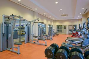 Fitnesscenter im Novum Garden Side Hotel mit verschiedenen Geräten und Hanteln.