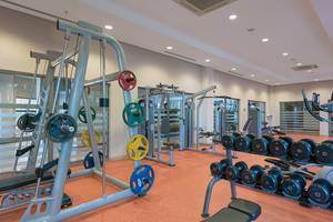 Fitnessbereich im Novum Garden Side Hotel mit verschiedenen Trainingsgeräten und Hanteln.