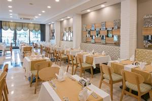 Restaurant des Novum Garden Side Hotels mit gedeckten Tischen und dekorativen Wänden.