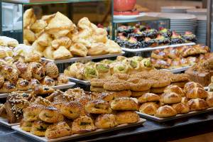 Ein Buffet mit einer Vielzahl von Gebäcksorten und Broten, darunter Croissants, Bagels und Brötchen.