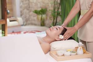 Massage im Bandara Resort & Spa, Samui mit einer Frau, die eine Gesichtsmassage durchführt.