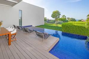 Außenbereich des Oberoi Beach Resort Al Zorah mit Terrasse, Tisch, Stühlen und Pool