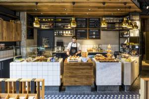 Im Novotel London Canary Wharf Hotel Innenansicht des Cafés mit Barista bei der Arbeit.