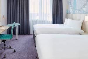 Doppelzimmer im Leonardo Hotel London Croydon mit zwei Betten, Schreibtisch und Fernseher.