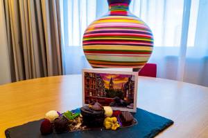 Ein süßes Dessert mit einem Kuchen, Pralinen und Früchten auf einem blauen Teller im Novotel London West.