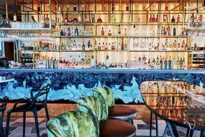 Bar im DoubleTree by Hilton Tower of London mit blauem Wanddesign und vielen Getränken