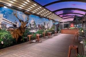 Innenbereich des DoubleTree by Hilton Tower of London mit hölzernem Boden, Stühlen und einer großen Wandmalerei